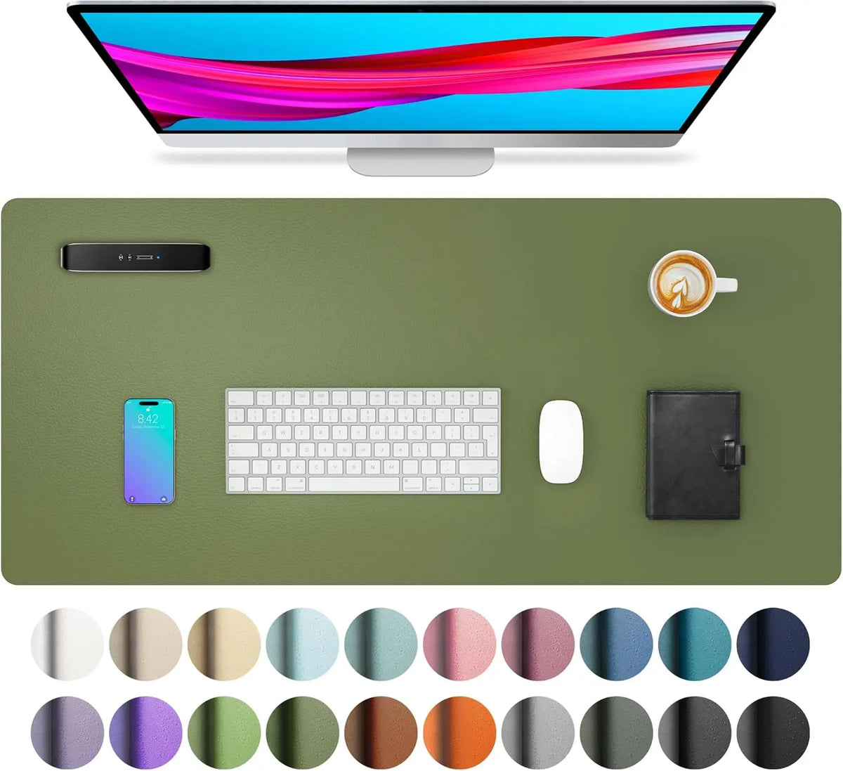 A computer monitor displays colorful graphics, surrounded by a green desk pad, a smartphone, keyboard, mouse, and a leather n