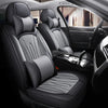 Interior view of a car showing black leather seat covers with gray stitching and headrests.