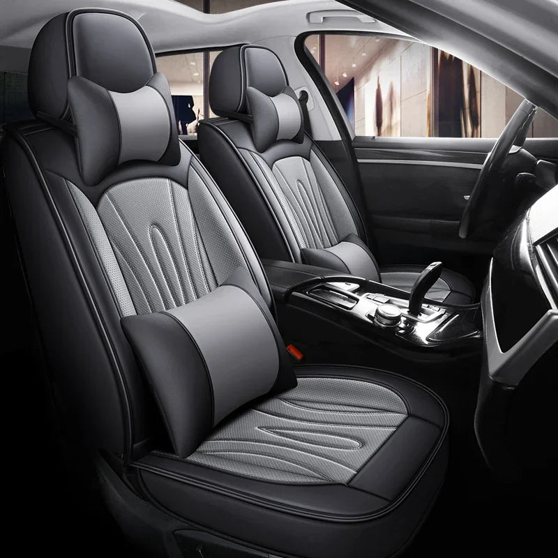 Interior view of a car showing black leather seat covers with gray stitching and headrests.