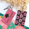 Pink and black floral patterned PU leather card holder keychain with a spade design