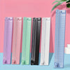 A row of colorful portable paper cutter trimmers in various shades including purple, pink, green, black, and blue.