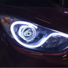 Close-up of a vehicle's headlight featuring a bright LED design with a central eye motif.
