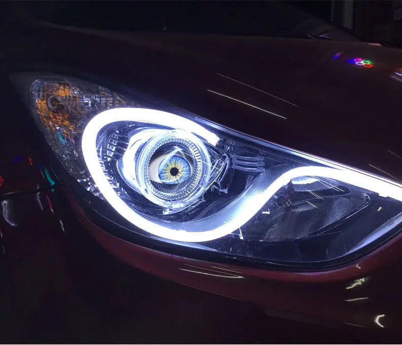 Close-up of a vehicle's headlight featuring a bright LED design with a central eye motif.
