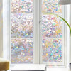 A window covered with 3D rainbow privacy film featuring stained glass decorative vinyl patterns.