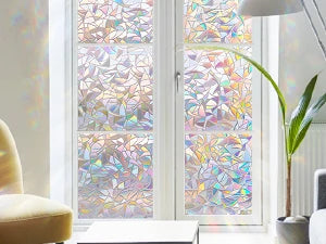 A window covered with 3D rainbow privacy film featuring stained glass decorative vinyl patterns.