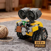 Set de bloques de construcción mini robot amarillo y gris con ojos negros grandes y boquilla verde sobre superficie de tela g