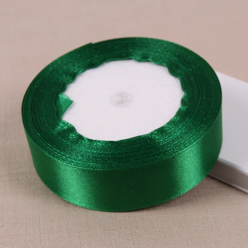 Roll of lustrous satin ribbon in emerald green for gift wrapping and crafts