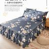Un lit bleu foncé avec une jupe froncée à imprimé floral blanc, mettant en valeur le tissu doux et délicat.