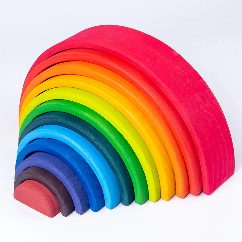 A set of wooden rainbow stacking blocks in a vibrant spectrum of colors arranged in an arc.