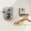 A silver retractable clothesline with a gold-colored hanging mechanism mounted on a wall.