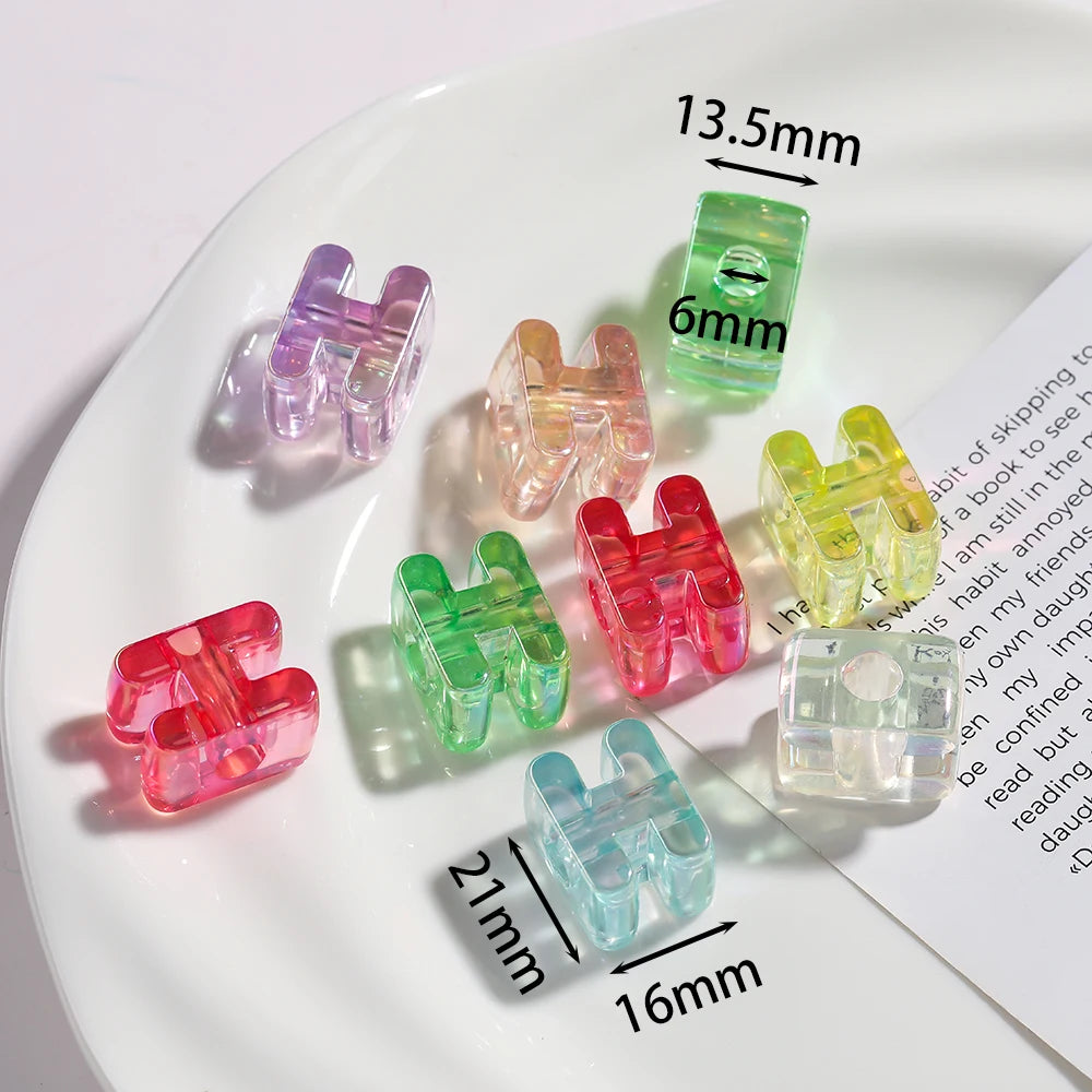 Various colored acrylic alphabet beads displayed on a white plate with measurement lines.