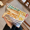 A canvas storage pouch with multicolored stripes in orange, purple, and yellow.