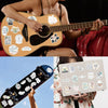 A person holds a guitar decorated with inspirational Bible verse stickers and a laptop decorated with similar stickers.