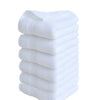 A stack of six white premium pure cotton face towels.