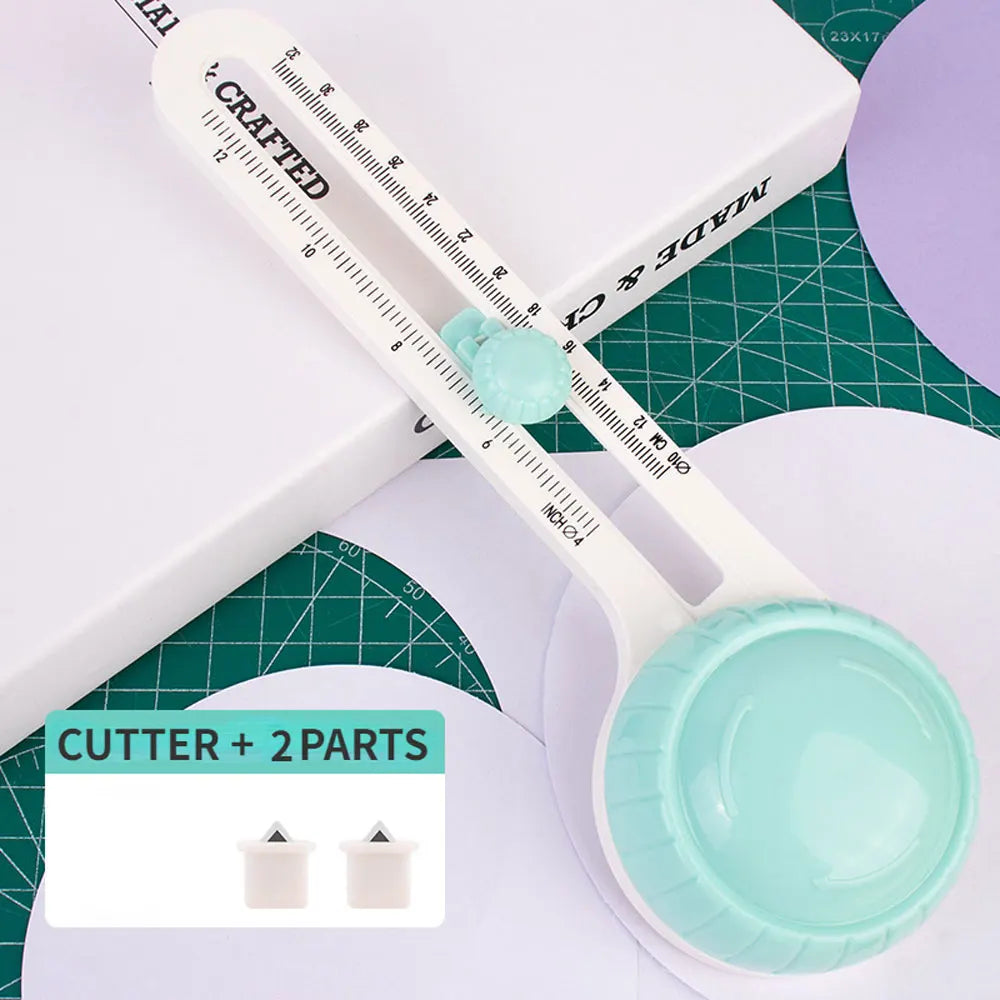 A white adjustable circular paper cutter with a clear measuring scale and two interchangeable blades is shown on a green cutt