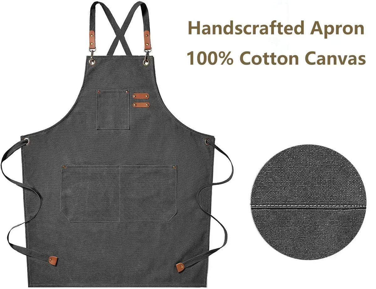 A dark gray handcrafted cotton canvas apron with cross-back straps and chest pockets.