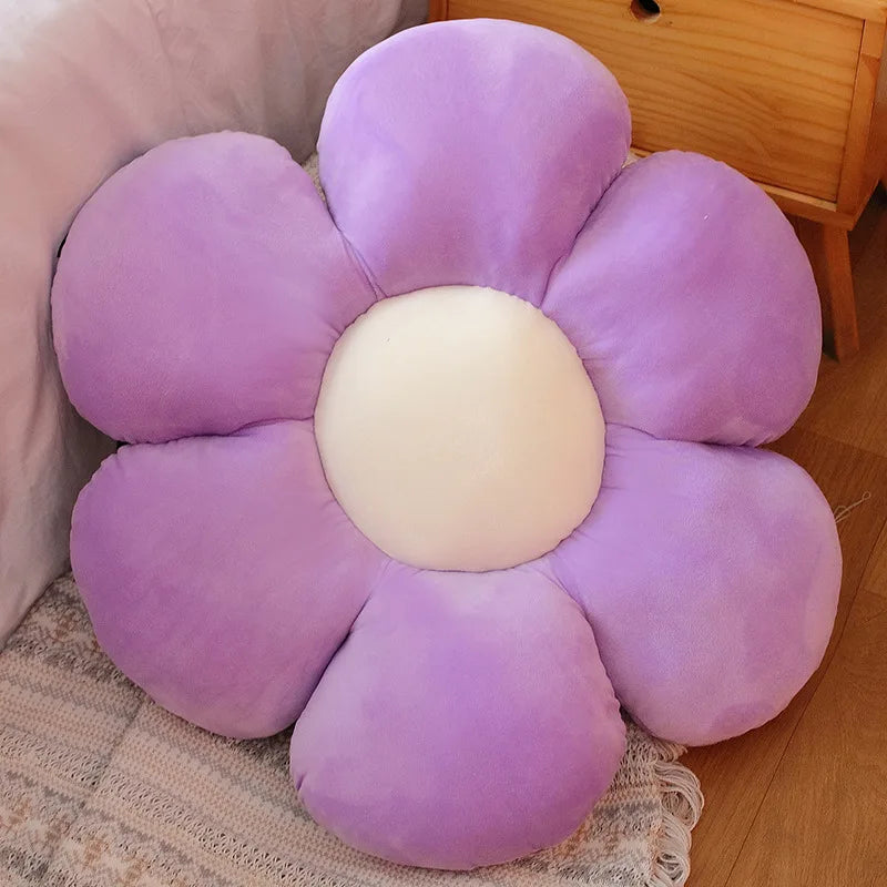 A purple and cream lifelike sunflower plush pillow with soft furry texture resting on a light-colored fabric.