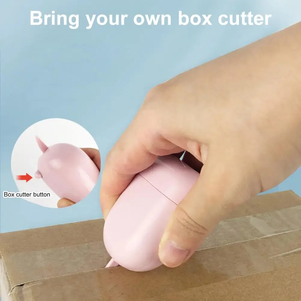 A hand is pressing the button on a pink box cutter, demonstrating how to use the tool.