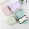 A collection of pink and mint green smiley face lidded soap dishes for bathroom and travel.