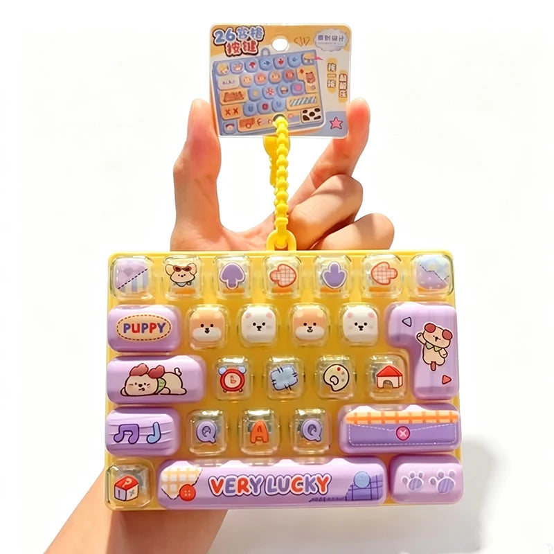 A yellow and purple fidget keychain featuring various cartoon-themed keycaps and a small plastic case.