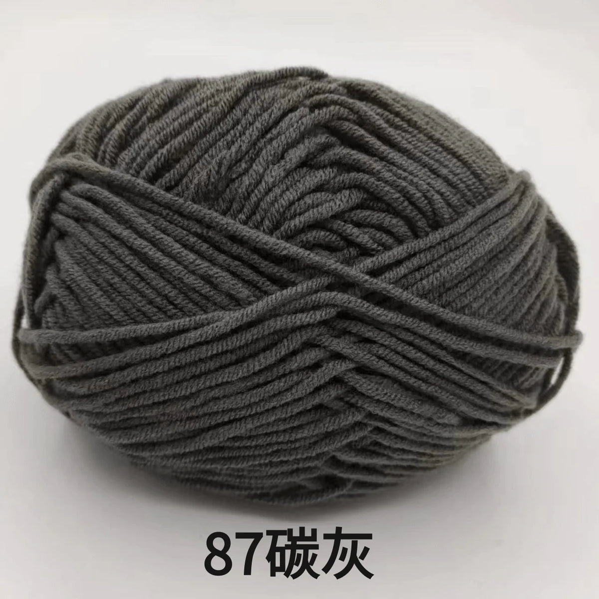 A ball of dark gray 4-ply milk cotton yarn for knitting and crochet.