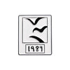 A rectangular enamel brooch featuring a stylized bird silhouette and the year 1989.