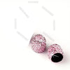 Ein Set rosa Kristall-Diamant-Radventilkappen mit schwarzen Zentren.
