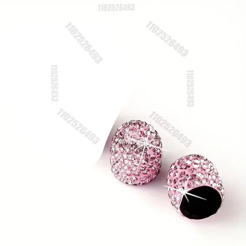 Ein Set rosa Kristall-Diamant-Radventilkappen mit schwarzen Zentren.
