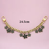 Gold chain phone strap featuring decorative black flower charms and a lobster clasp.