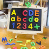 A magnetic alphabet learning set featuring colorful letters and numbers scattered on a wooden surface.