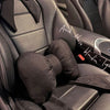 A black butterfly bow tie neck pillow with a dark cover is shown in the interior of a car seat.