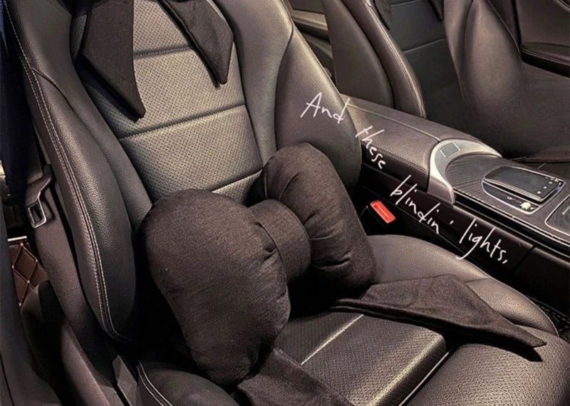 A black butterfly bow tie neck pillow with a dark cover is shown in the interior of a car seat.