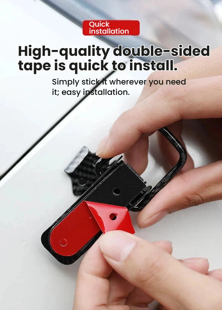 A hand is installing a black and red alloy hood pin lock kit onto a white surface.