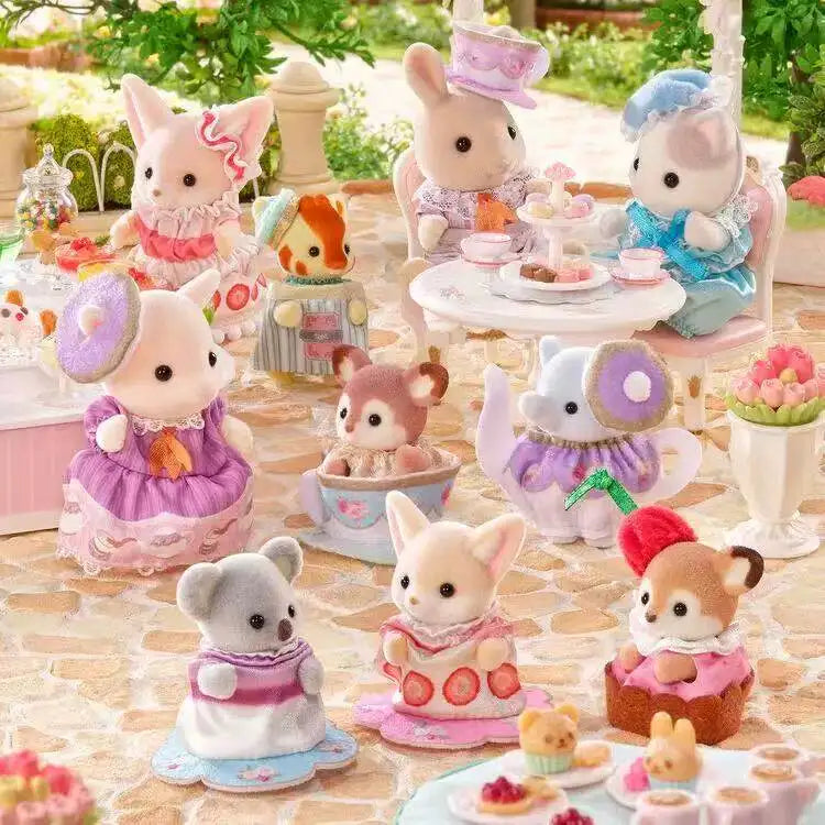 A collection of Sylvanian Families tea party baby figures and blind bag collectibles arranged on a table.