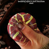 A hand holds a red and yellow chocolate crisp, showing its texture and satisfying break apart.
