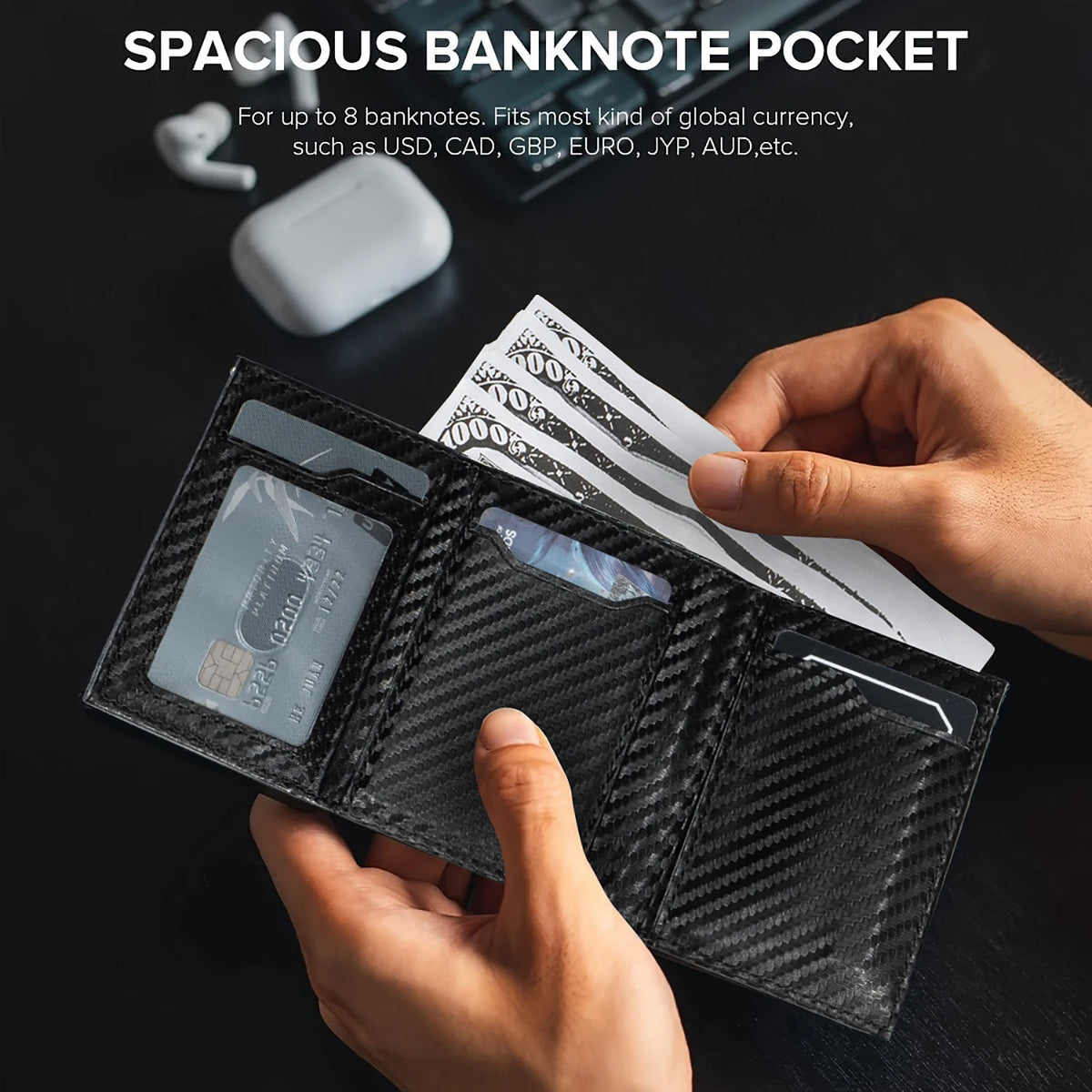 A hand holds a black wallet with a carbon fiber texture, displaying various banknotes and currency.