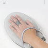 A hand wearing a grey ironing glove is shown resting on a light gray ironing board.