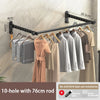 A black 10-hole wall-mounted clothes drying rack with a 76cm rod is shown hanging clothes on a wall.