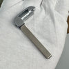 A silver replacement remote key for a Chevrolet or GMC vehicle is shown held in a hand.