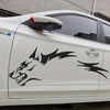A white car door features black vinyl decals shaped like a wolf head and lightning bolts.
