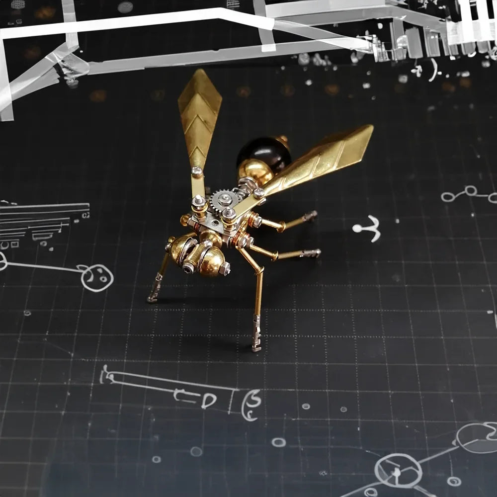A detailed metal insect puzzle decor featuring gold and bronze components placed on a dark surface with technical drawings.