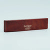 A wooden acoustic guitar bridge saddle with the inscription Guyker 4630