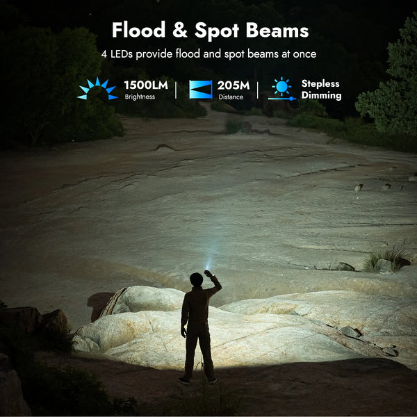 A person is using a flood and spot beam flashlight in an outdoor, rocky environment.