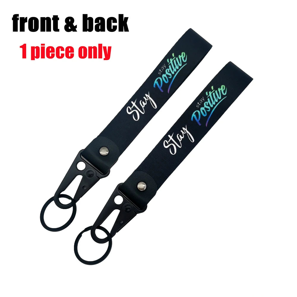 A black lanyard with a stay positive message on the front and back, featuring an eagle beak clasp.
