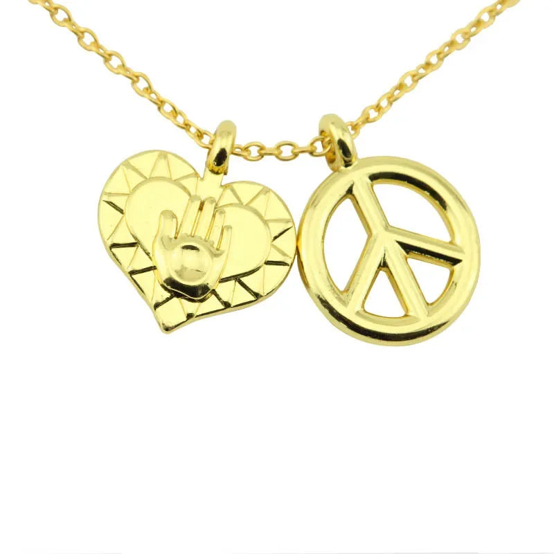 Gold pendant necklace featuring a heart charm and a peace sign design.