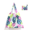 A reusable shopping tote bag featuring a vibrant tropical leaf print in shades of pink, blue, and green.