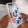 A hand holds a clear white magnetic phone case featuring a blue lily design on a wooden surface.