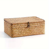 A rectangular woven rattan storage basket with a lid, made of natural light brown material.