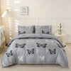 A gray duvet cover set with butterfly print and matching pillowcases displayed on a bed.