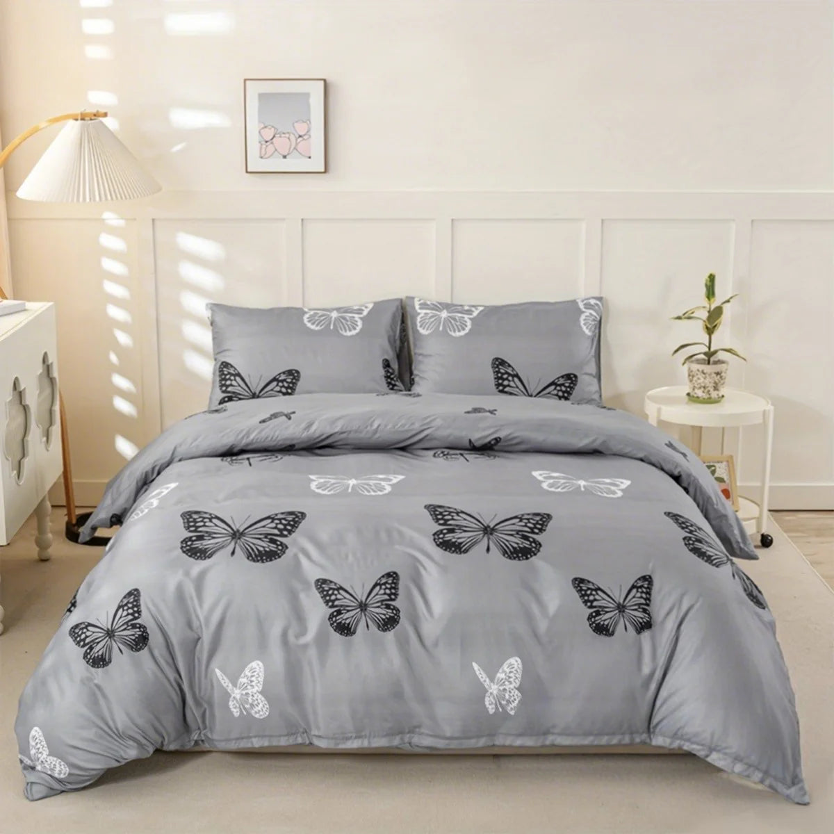 A gray duvet cover set with butterfly print and matching pillowcases displayed on a bed.